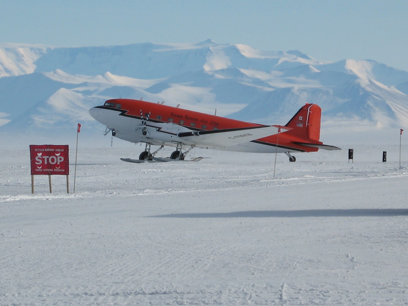 A USAP fixed-wing aircraft parked on a snow airstrip