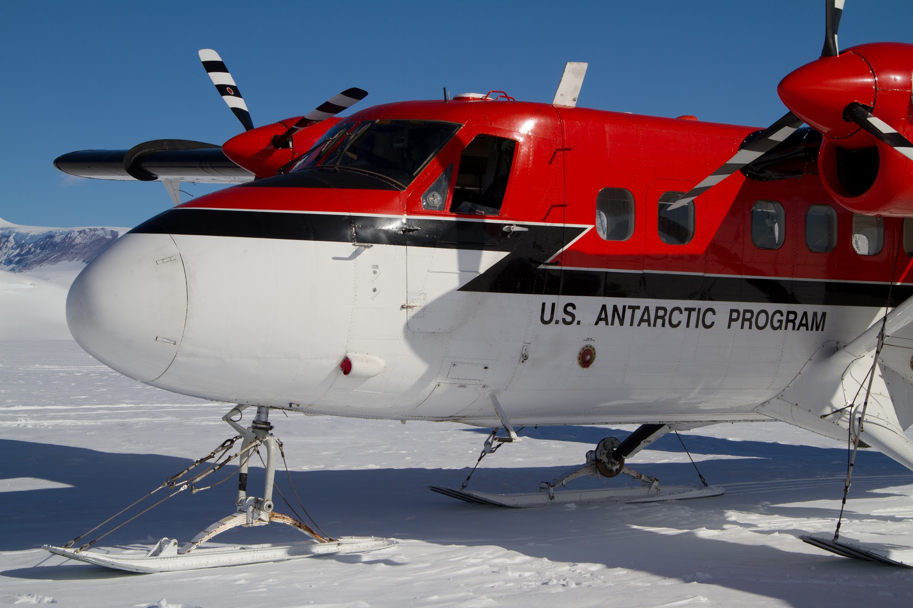 Closeup of a USAP fixed-wing aircraft parked on a snow airstrip